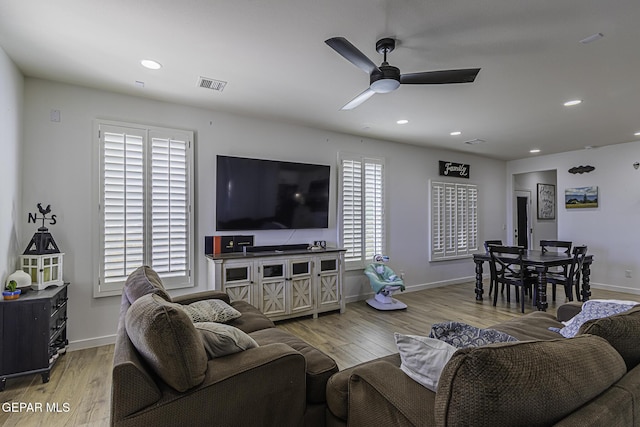 living room with ceiling fan and light hardwood / wood-style flooring