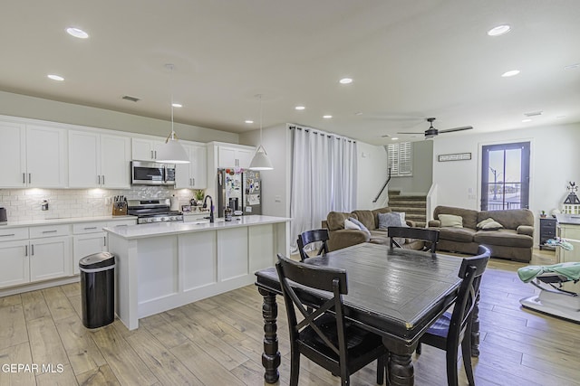 dining space featuring sink, light hardwood / wood-style flooring, and ceiling fan