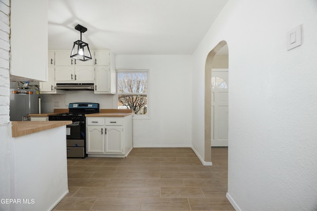 kitchen featuring stainless steel range, white cabinets, hanging light fixtures, and wood counters