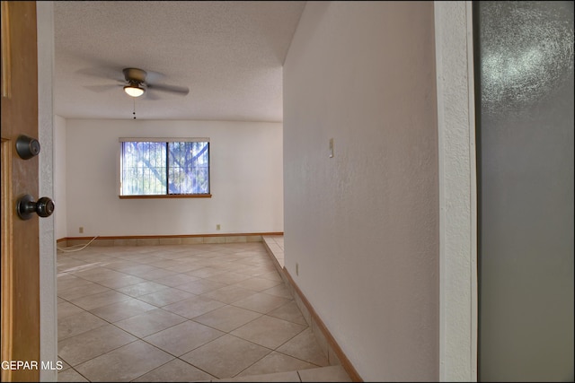 tiled empty room with a textured ceiling and ceiling fan