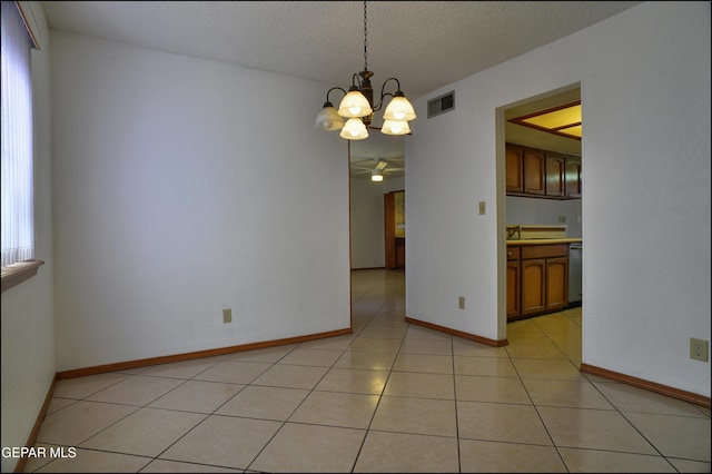 unfurnished room with ceiling fan with notable chandelier, sink, light tile patterned floors, and a textured ceiling