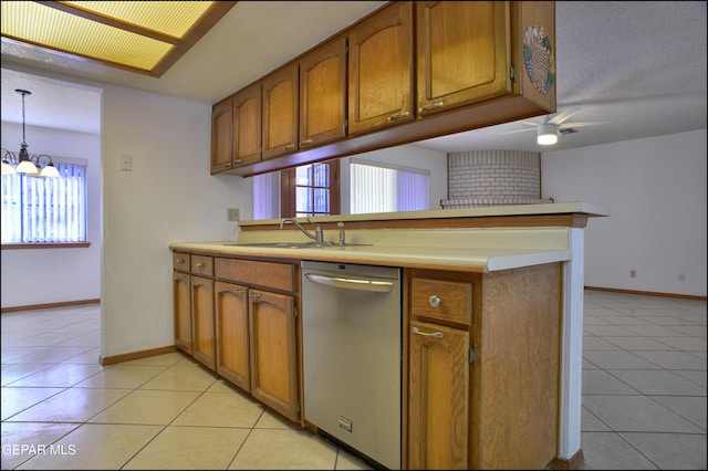 kitchen featuring stainless steel dishwasher, plenty of natural light, light tile patterned floors, and hanging light fixtures