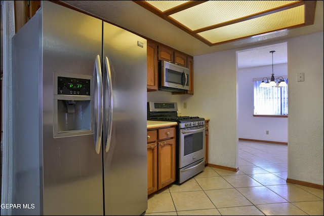 kitchen featuring decorative light fixtures, light tile patterned floors, stainless steel appliances, and a chandelier