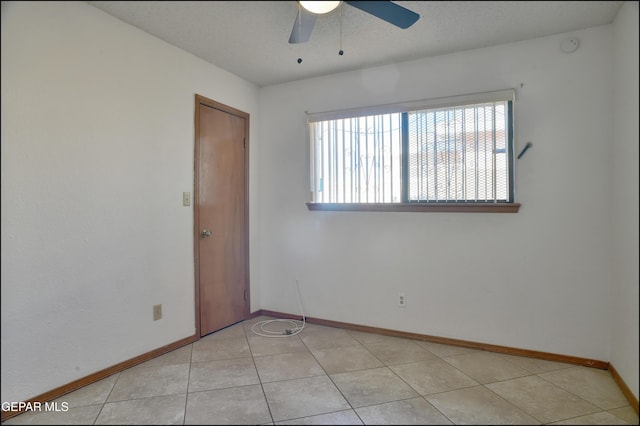 tiled spare room featuring a textured ceiling and ceiling fan