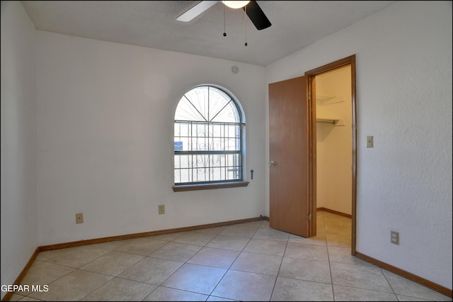 tiled empty room with ceiling fan