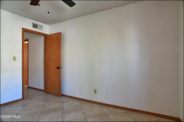 unfurnished room with light tile patterned floors and a textured ceiling