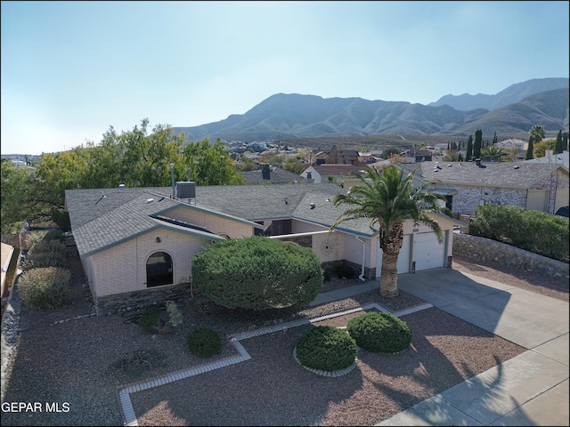 exterior space featuring a mountain view, central AC unit, and a garage