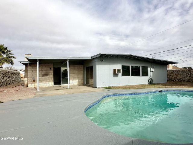 back of property with a wall mounted air conditioner and a patio area