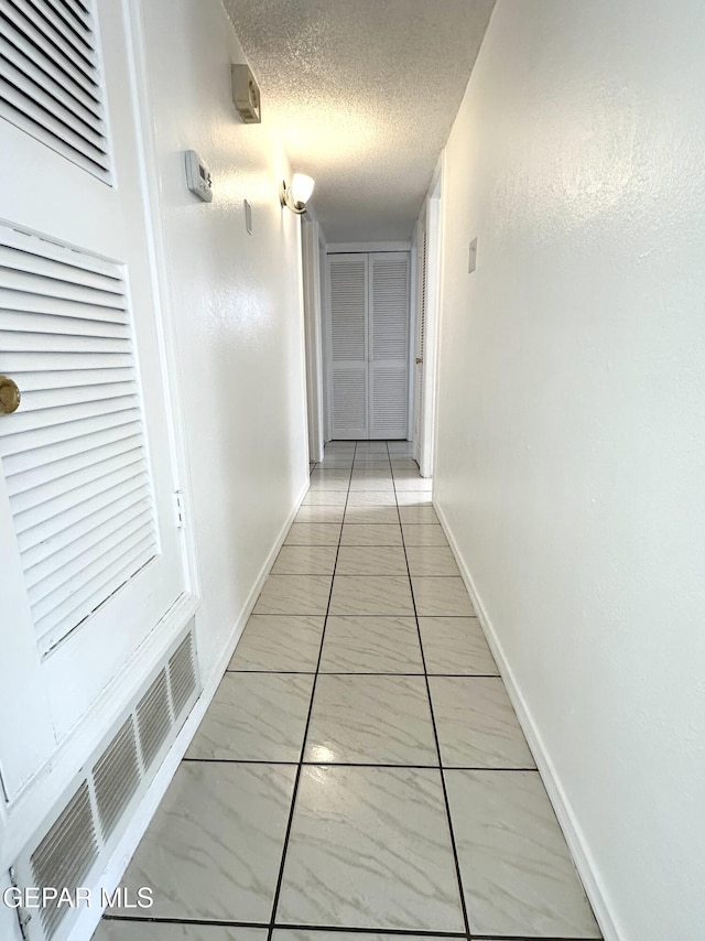 hall featuring a textured ceiling