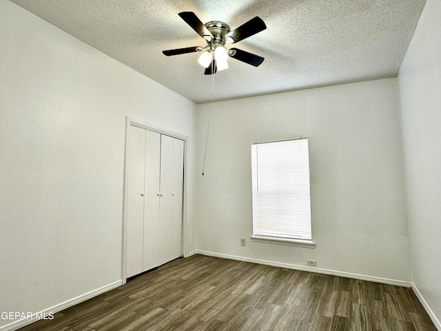 unfurnished bedroom with ceiling fan, a closet, wood-type flooring, and a textured ceiling