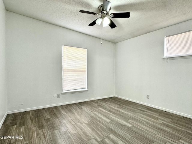 unfurnished room with wood-type flooring, a textured ceiling, and plenty of natural light