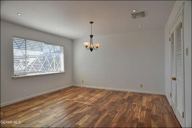 unfurnished room featuring hardwood / wood-style floors and a notable chandelier