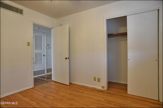 unfurnished bedroom featuring light wood-type flooring and a closet