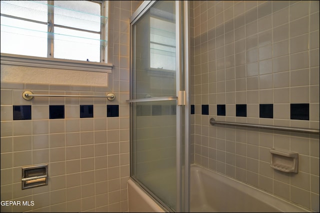 bathroom featuring combined bath / shower with glass door