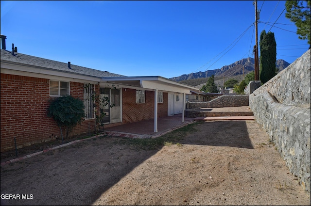 exterior space featuring a mountain view and a patio area