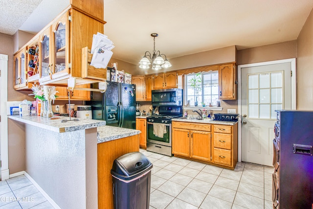 kitchen with kitchen peninsula, appliances with stainless steel finishes, light tile patterned floors, decorative light fixtures, and an inviting chandelier