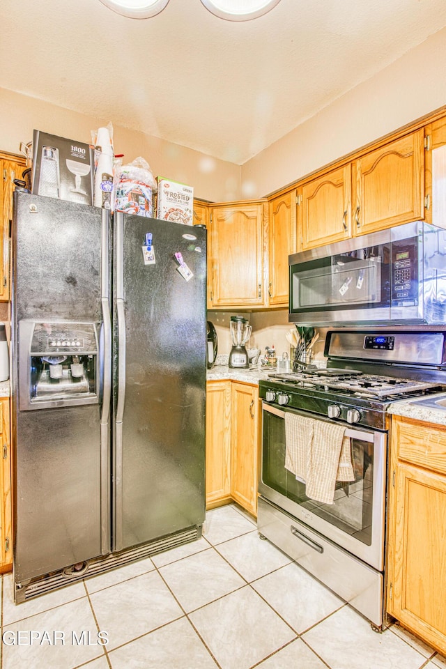 kitchen with light tile patterned flooring and stainless steel appliances