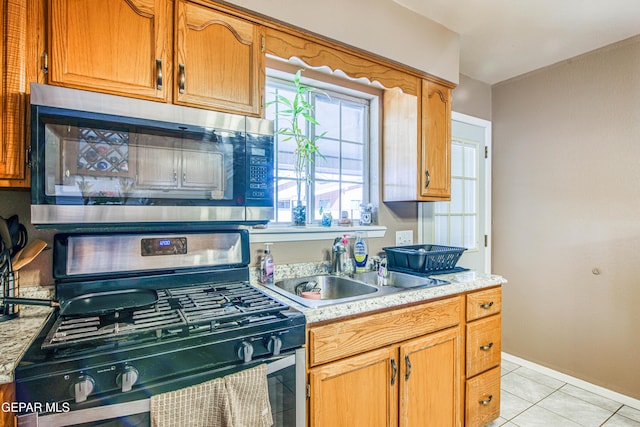 kitchen with sink, black range with gas cooktop, and light tile patterned flooring