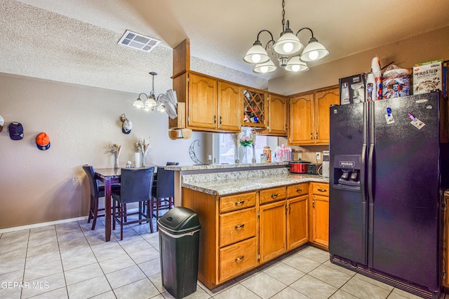 kitchen featuring a notable chandelier, hanging light fixtures, a textured ceiling, and black refrigerator with ice dispenser