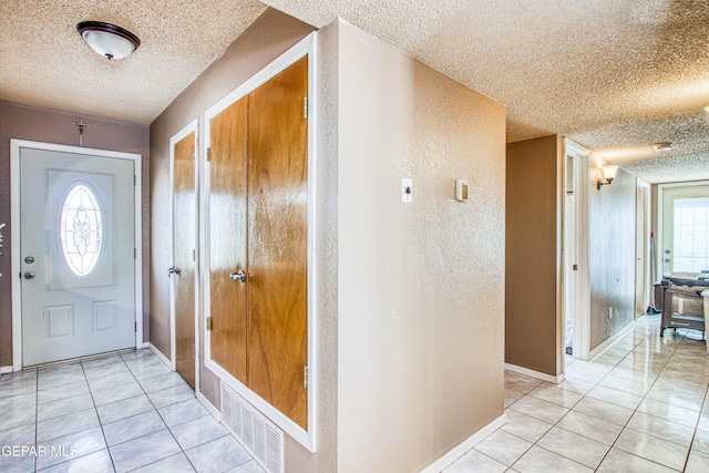 entrance foyer featuring light tile patterned floors and a textured ceiling