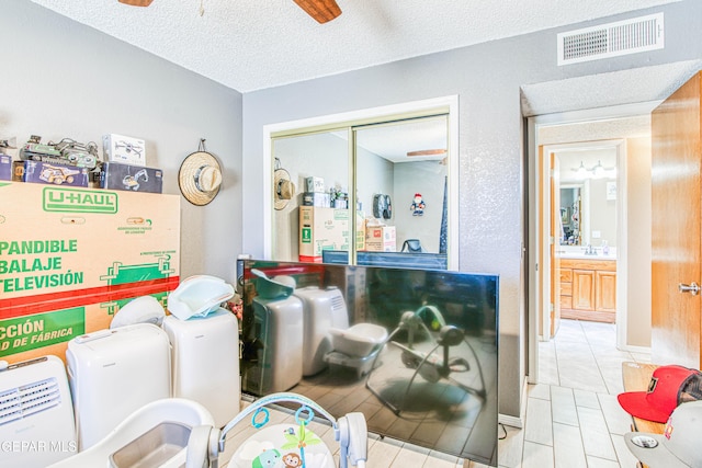 interior space featuring ceiling fan and a textured ceiling