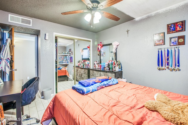 bedroom with ceiling fan, a closet, and a textured ceiling