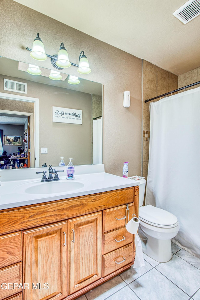 bathroom featuring vanity, tile patterned flooring, toilet, a textured ceiling, and walk in shower