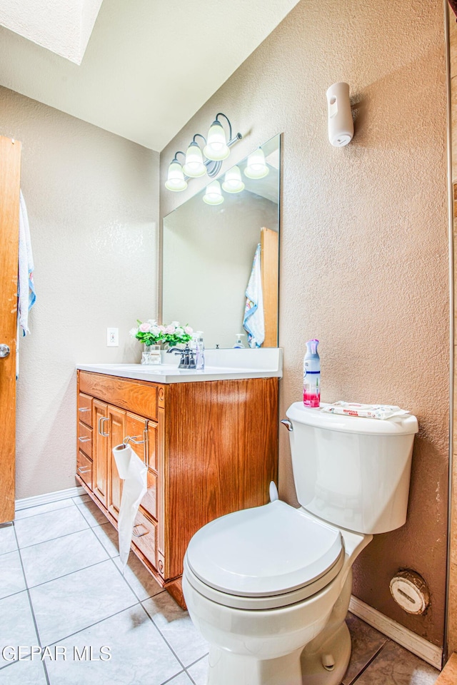 bathroom featuring tile patterned flooring, vanity, and toilet