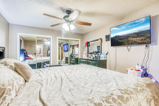 bedroom with two closets, ceiling fan, and a textured ceiling