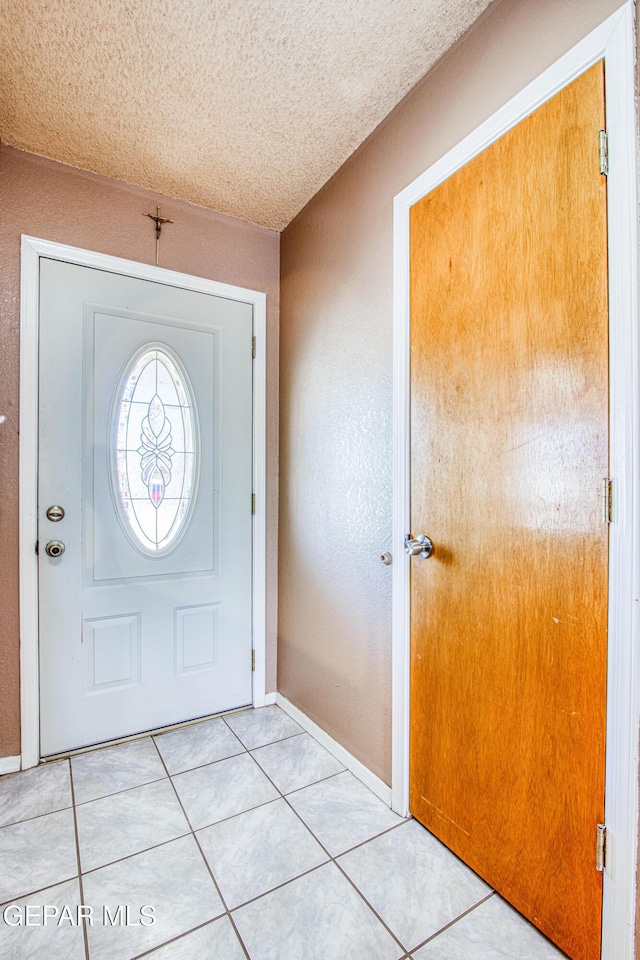 entrance foyer featuring light tile patterned floors and a textured ceiling