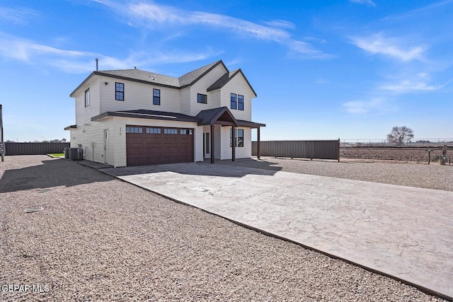 view of front of house with a garage and central AC unit