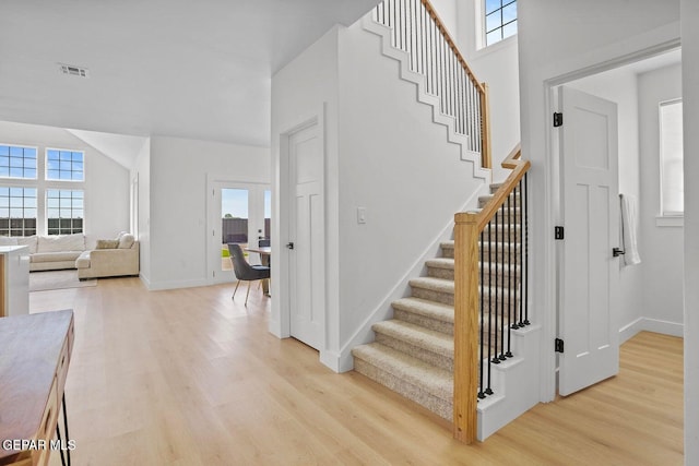 staircase with hardwood / wood-style floors, a healthy amount of sunlight, and french doors