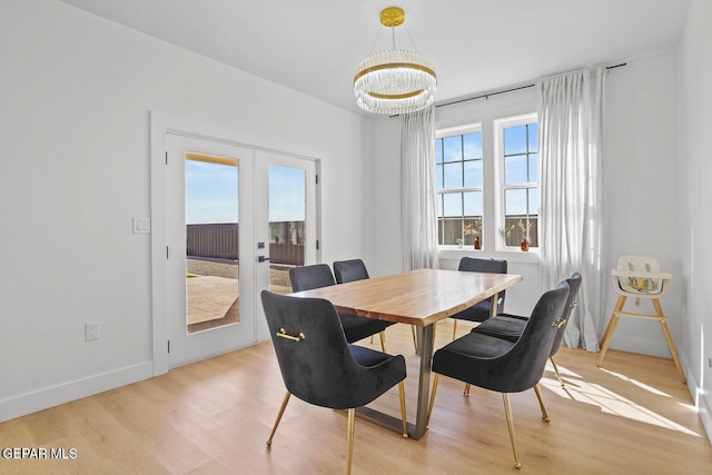 dining space featuring french doors, light hardwood / wood-style floors, and a notable chandelier