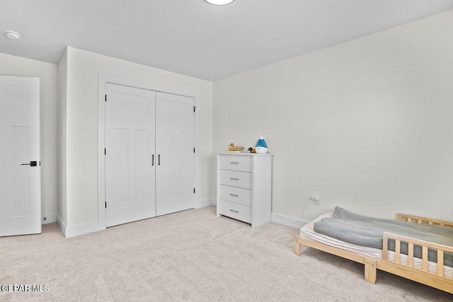 bedroom featuring light colored carpet and a closet