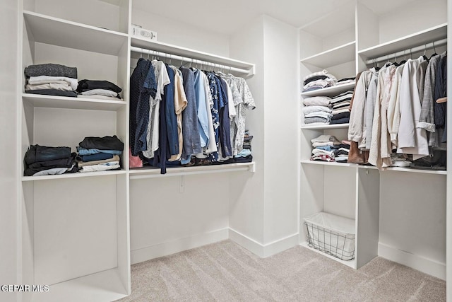 walk in closet featuring light colored carpet