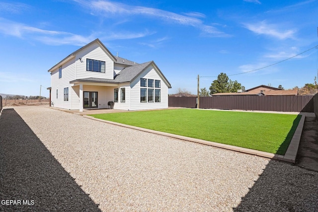 back of house with a yard and a patio area