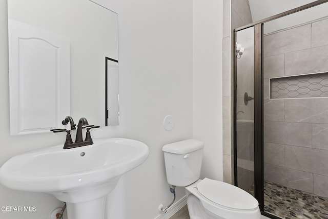 bathroom with toilet, an enclosed shower, and sink