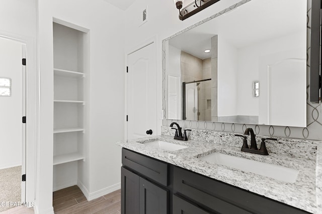 bathroom with vanity, wood-type flooring, and an enclosed shower