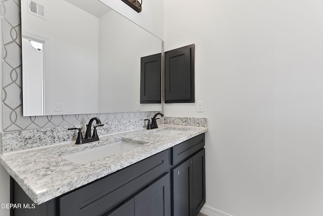 bathroom featuring vanity and decorative backsplash