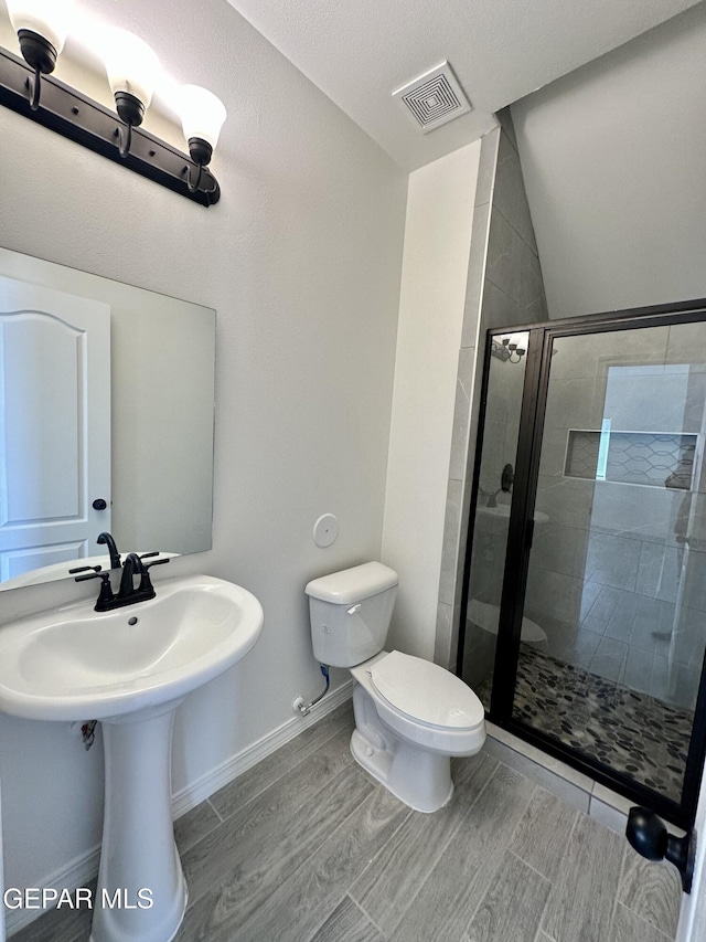 bathroom featuring an enclosed shower and toilet