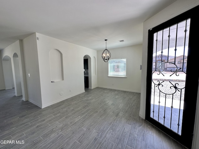 interior space with a notable chandelier and hardwood / wood-style flooring