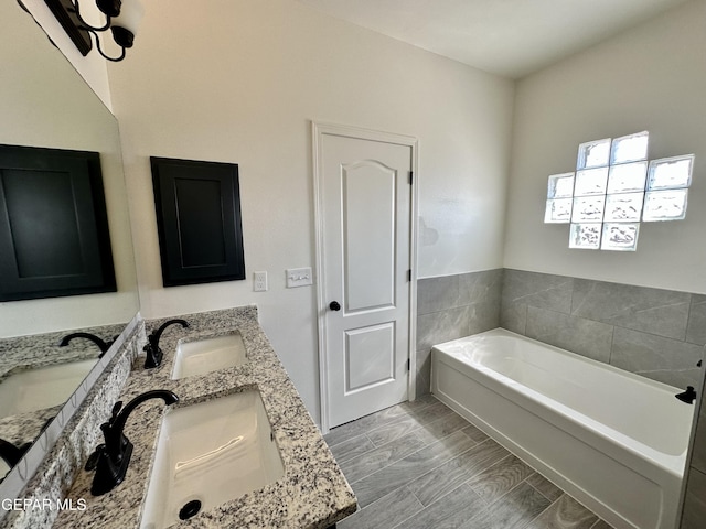 bathroom with a tub to relax in, hardwood / wood-style floors, and vanity