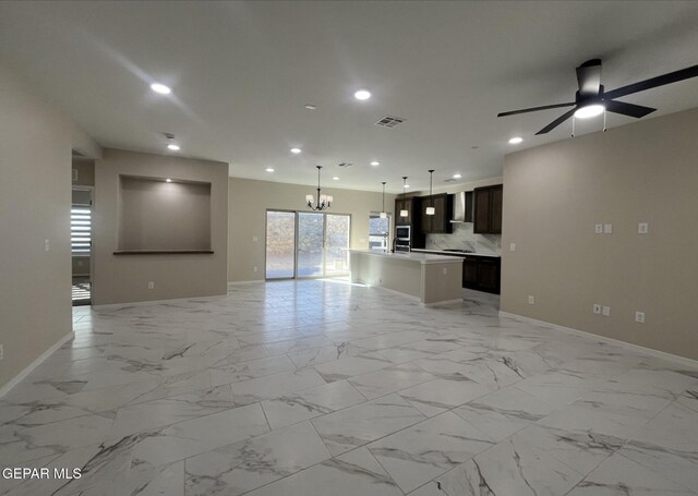 unfurnished living room with ceiling fan with notable chandelier