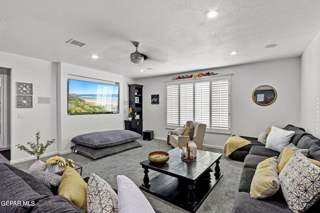 carpeted living room with ceiling fan and a textured ceiling