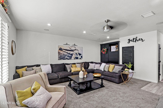 carpeted living room featuring ceiling fan