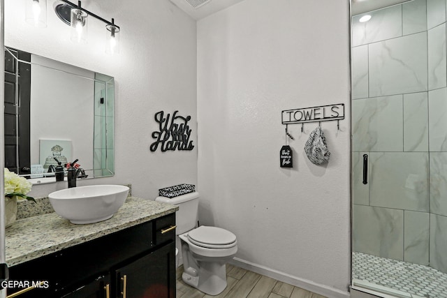 bathroom featuring walk in shower, vanity, wood-type flooring, and toilet