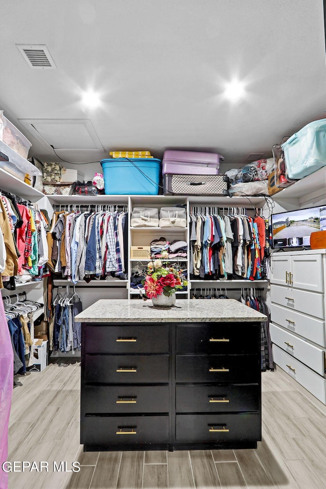 spacious closet featuring light hardwood / wood-style floors