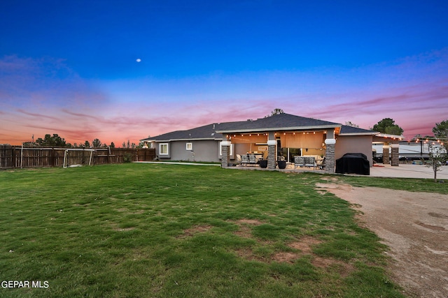 back house at dusk featuring a yard