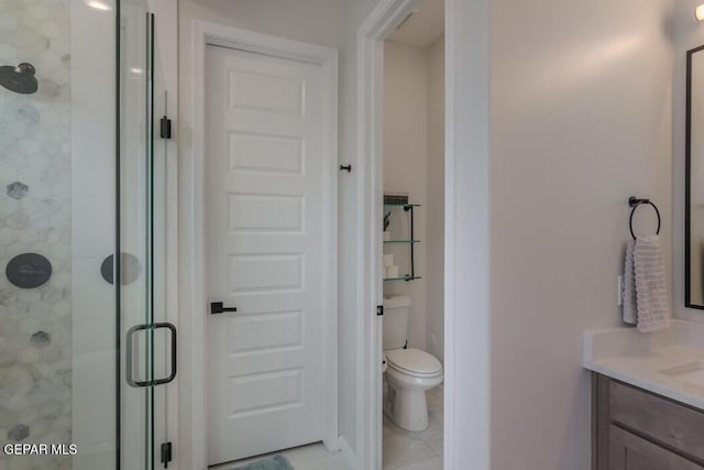 bathroom featuring tile patterned flooring, vanity, toilet, and an enclosed shower