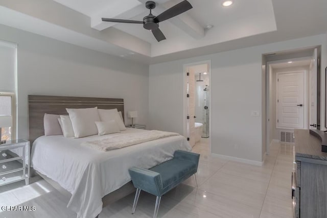 bedroom with ceiling fan, connected bathroom, and a tray ceiling